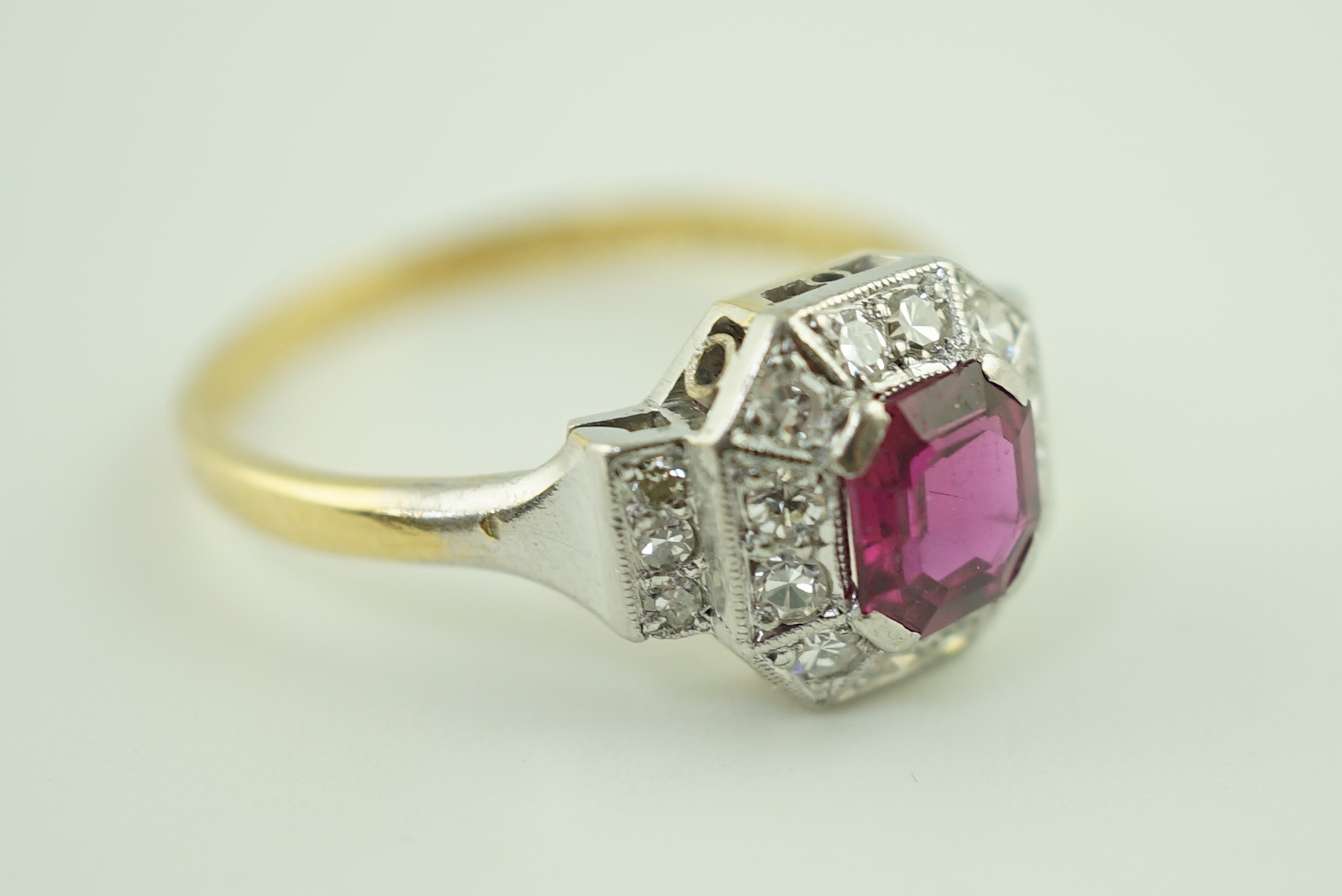 A 1950's Art Deco 18ct gold and platinum, ruby and millegrain set diamond octagonal cluster ring
